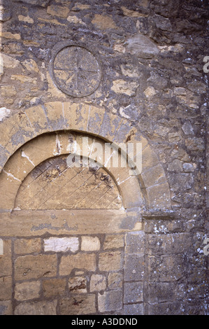 Saintbury in der Nähe des Broadway The Parish Church aus der Nähe der historischen sächsischen Sonnenuhr im alten Stil über einem Bogen zum Eingang von Gloucestershire England Stockfoto