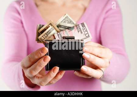 Frau mit Handtasche, überfüllt mit US-Dollar Stockfoto