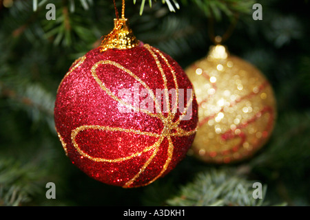 Zwei glitzerte Weihnachtskugeln an einem Baum hängen. Stockfoto