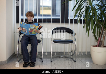 Ein Junge sitzt in einem Wartezimmer Stockfoto