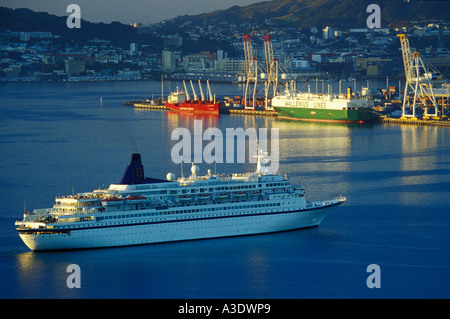 Kreuzfahrtschiff Norwegian Star nahenden Hafen bei Sonnenaufgang, Wellington, New Zealand, Frachter im Hintergrund Stockfoto