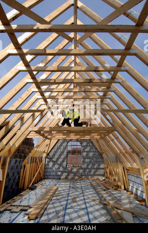 Ein Baumeister Vermessung der Dachstuhl eines neuen Hauses im Bau. Stockfoto