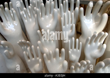 Resultate von weißem Porzellan Hände dehnen sich aus einer Anzeige von Latex-Handschuh-Formen Stockfoto