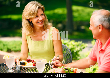 Älteres paar Platten mit Salat vor ihnen am Tisch sitzen Stockfoto
