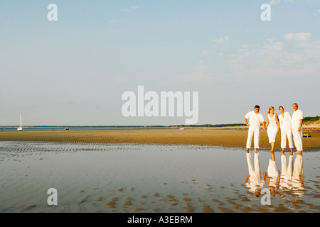 Älteres paar stehend mit einer Mitte erwachsenen Frau und einem reifen Mann am Strand Stockfoto