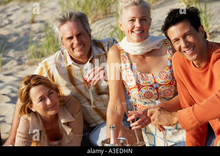 Porträt von zwei ältere Ehepaare am Strand sitzen und halten Sektgläser Stockfoto