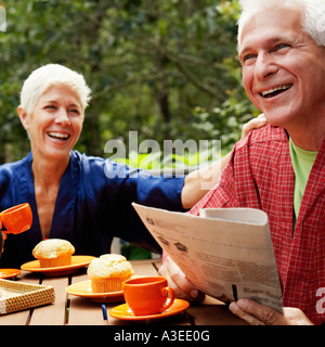 Nahaufnahme von einem reifen Mann und eine ältere Frau am Tisch sitzen und Lächeln Stockfoto