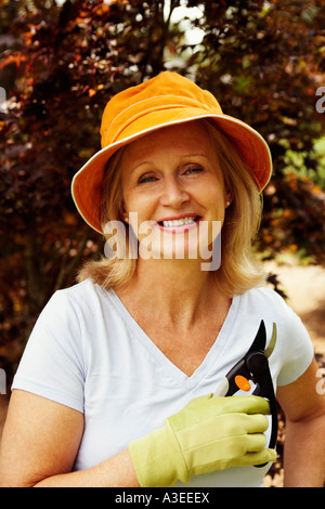 Porträt einer reifen Frau hält ein paar Gartenscheren und lächelnd Stockfoto