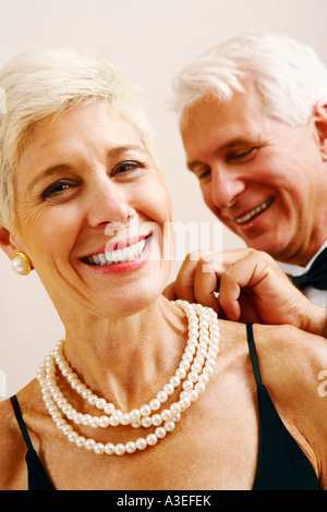 Nahaufnahme eines reifen Mannes setzen eine Perlenkette um eine ältere Frau Hals Stockfoto