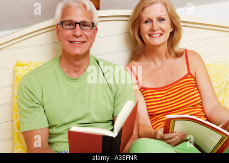 Porträt von ein älteres Paar auf dem Bett sitzen und Lächeln Stockfoto