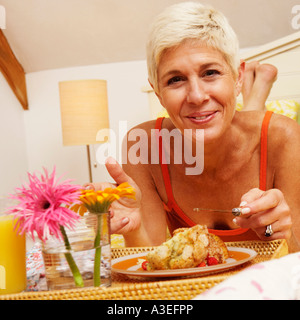 Porträt einer älteren Frau im Bett zu frühstücken Stockfoto
