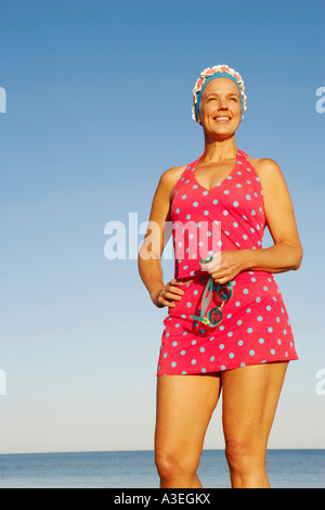 Niedrigen Winkel Ansicht einer reifen Frau am Strand stehen und Lächeln Stockfoto