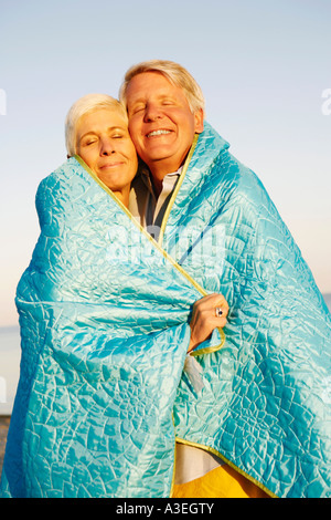 Ein älteres Paar in eine Decke gehüllt und lächelnd in Nahaufnahme Stockfoto