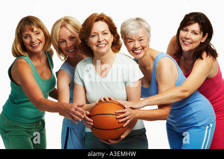 Porträt von fünf Reife Frauen halten einen Basketball und lächelnd Stockfoto
