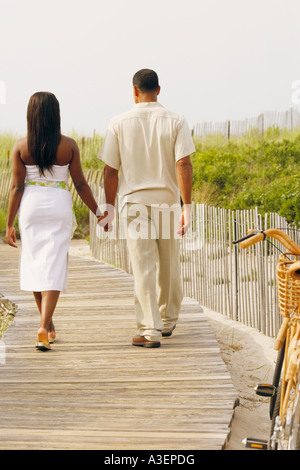 Ansicht von hinten ein paar zu Fuß auf einem Holzsteg mit ihren Händchen Stockfoto