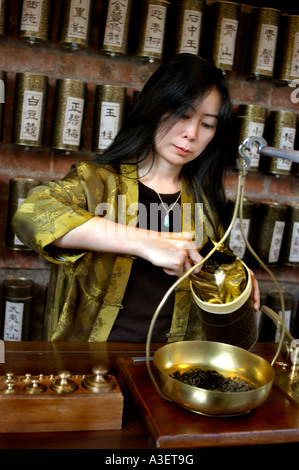 PARIS FRANKREICH, chinesischer Teehandelsspezialist „Yu Hui Tseng“ wiegt schwarzen Tee auf der Waage im Teestube Store „La Maison des Trois Thés“ in paris, Stockfoto