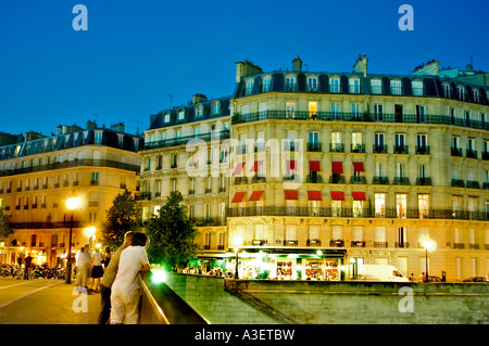 Paris Frankreich, Paar junge Erwachsene hängen an der Brücke 'Pont St Louis' 'Ile Saint Louis' auf der seine-Apartmentgebäude bei Nacht frankreich herum Stockfoto