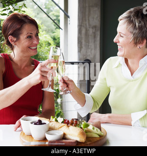 Zwei Reife Frauen Toasten mit Champagner-Flöten in Nahaufnahme Stockfoto