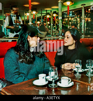 Zwei französische weibliche asiatische Teenager-Mädchen plaudern im French Cafe Paris, Frankreich, trinken Kaffee, Teenager hängen im Café, französisch Frau paris Café, Stockfoto