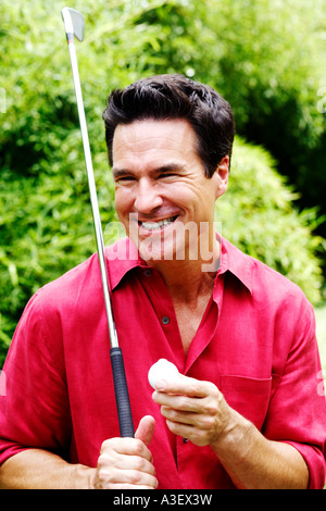 Nahaufnahme von einem reifen Mann hält ein Golfclub und ein Golfball Stockfoto