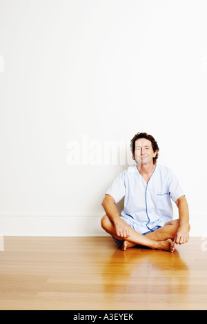 Porträt von einem reifen Mann sitzt im Schneidersitz auf dem Boden und lächelnd Stockfoto