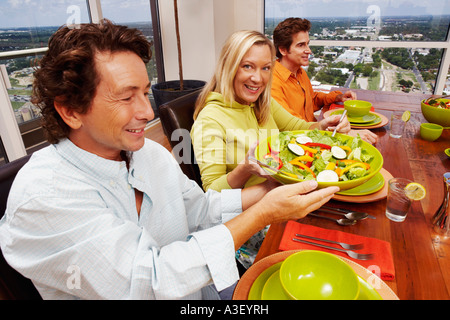 Porträt einer reifen Frau und zwei reife Männer sitzen am Esstisch Stockfoto