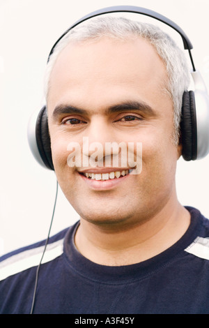 Nahaufnahme eines Mitte erwachsenen Mannes anhören von Musik Stockfoto