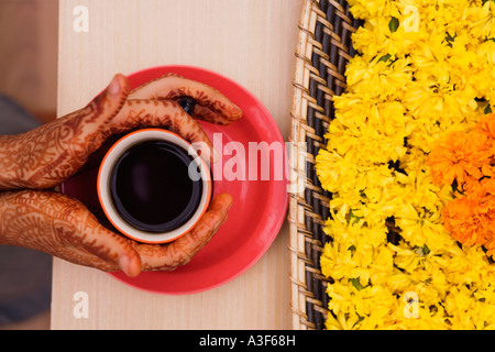 Nahaufnahme einer Frau Henna tätowiert Händen mit einer Tasse Tee Stockfoto