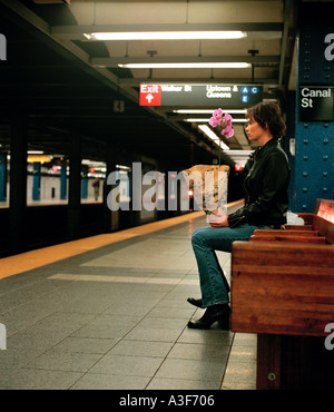 einsames Mädchen sitzen in New York u-Bahn Station Wth Orchidee Stockfoto