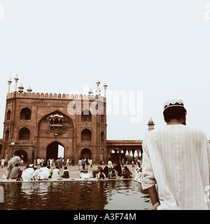 Rückansicht einer Gruppe von Menschen sitzen vor einer Moschee, Jama Masjid, Neu-Delhi, Indien Stockfoto