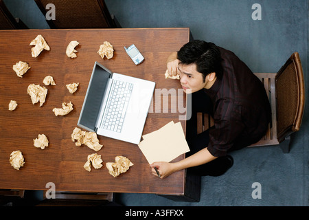 Erhöhte Ansicht eines Geschäftsmannes eine Papier halten und denken Stockfoto