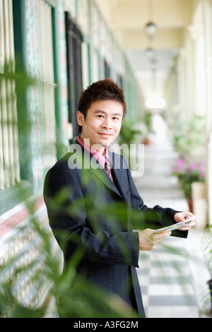 Porträt eines Geschäftsmannes Post halten und Lächeln Stockfoto