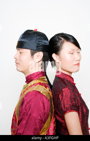 Seitenansicht von einem jungen Mann und eine junge Frau stehen Rücken an Rücken mit ihren Augen geschlossen Stockfoto