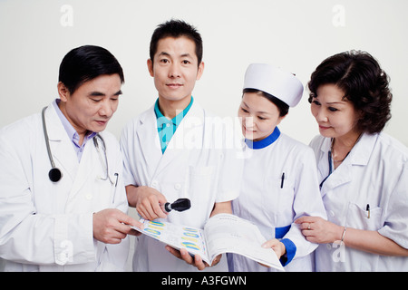 Zwei männliche Ärzte und eine Krankenschwester, ein Bericht Stockfoto