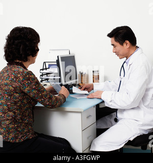 Nahaufnahme von einem männlichen Arzt mit dem Patienten in seinem Büro Stockfoto