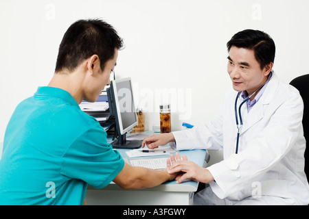 Männlichen Arzt des Patienten Puls überprüfen Stockfoto