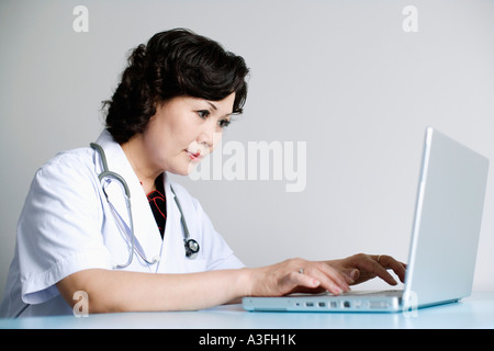 Nahaufnahme von einer Ärztin an einem Notebook arbeitet Stockfoto