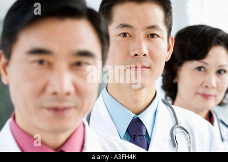 Porträt von zwei männlichen Ärzten mit einer Ärztin Stockfoto