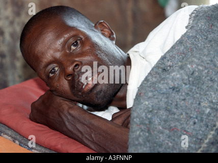 Südafrika, Mann mit der Immunschwäche HIV AIDS auf einem Bett in seiner Hütte Stockfoto