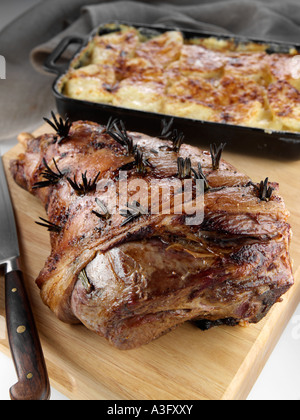 Gebratene Lammkeule auf ein Schneidebrett mit Dauphinoise Kartoffeln redaktionelle Essen Stockfoto