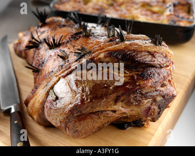 Gebratene Lammkeule auf ein Schneidebrett mit Dauphinoise Kartoffeln redaktionelle Essen Stockfoto