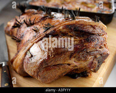 Gebratene Lammkeule auf ein Schneidebrett mit Dauphinoise Kartoffeln redaktionelle Essen Stockfoto