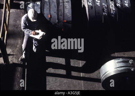 Draufsicht der Ingenieur in einem weißen Schutzhelm sitzen auf einer Offshore-Ölbohrplattform Notizen. Stockfoto