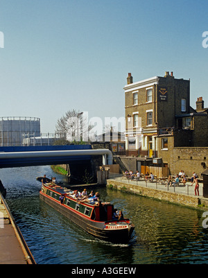 Narrowboat Ausflugsschiff vorbei Fullers Pub an der Seite von The Grand Union Canal bei Kensal Town im Nordwesten von London Stockfoto