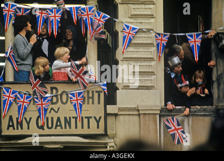 junge Zuschauer wehende Fahnen von Balkonen in London feiert die Queen s silbernes Jubiläum 1977 Stockfoto