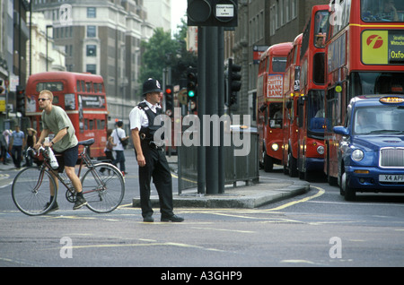 Ein englischer Bobby regelt den Verkehr auf der Oxford Street im Zentrum von London, England Stockfoto