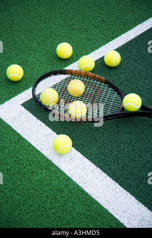 Tennisbälle und Tennisschläger am Tennisplatz liegen Stockfoto