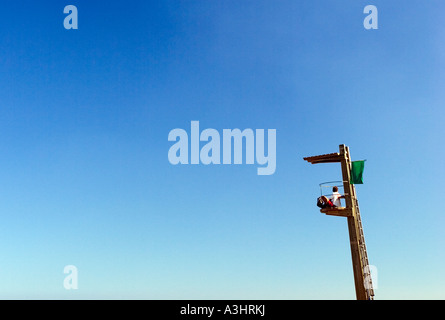 Bademeister sitzt auf einer Anzeige Post Vermessung die Badenden im Mittelmeer in Spanien Stockfoto