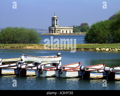 Anglian Water Trinkwasserspeicher in Rutland Water mit Normanton Kirche Museum im Querformat über kleine Fischerboote für Mietwagen East Midlands Großbritannien Stockfoto