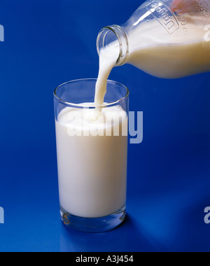 Glas Milch von Pint Flasche gießen Stockfoto